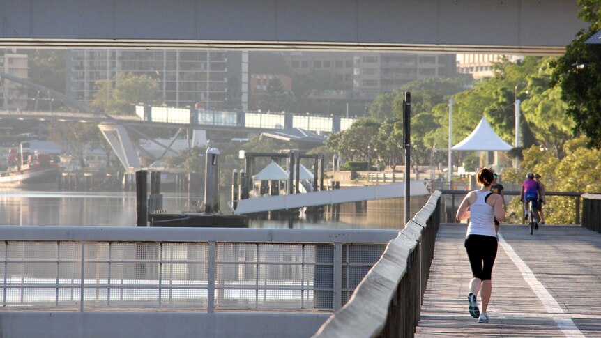 A woman jogs on boardwalk at South Bank.