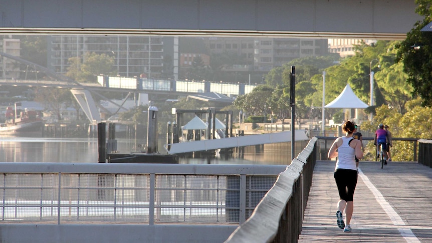 A woman embarks on an early morning jog along the boardwalk at South Bank, Brisbane, December 2012.