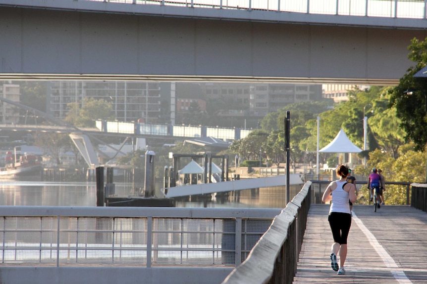 A woman jogs on boardwalk at South Bank.