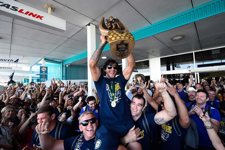 Thurston carries the NRL premiership trophy in Townsville
