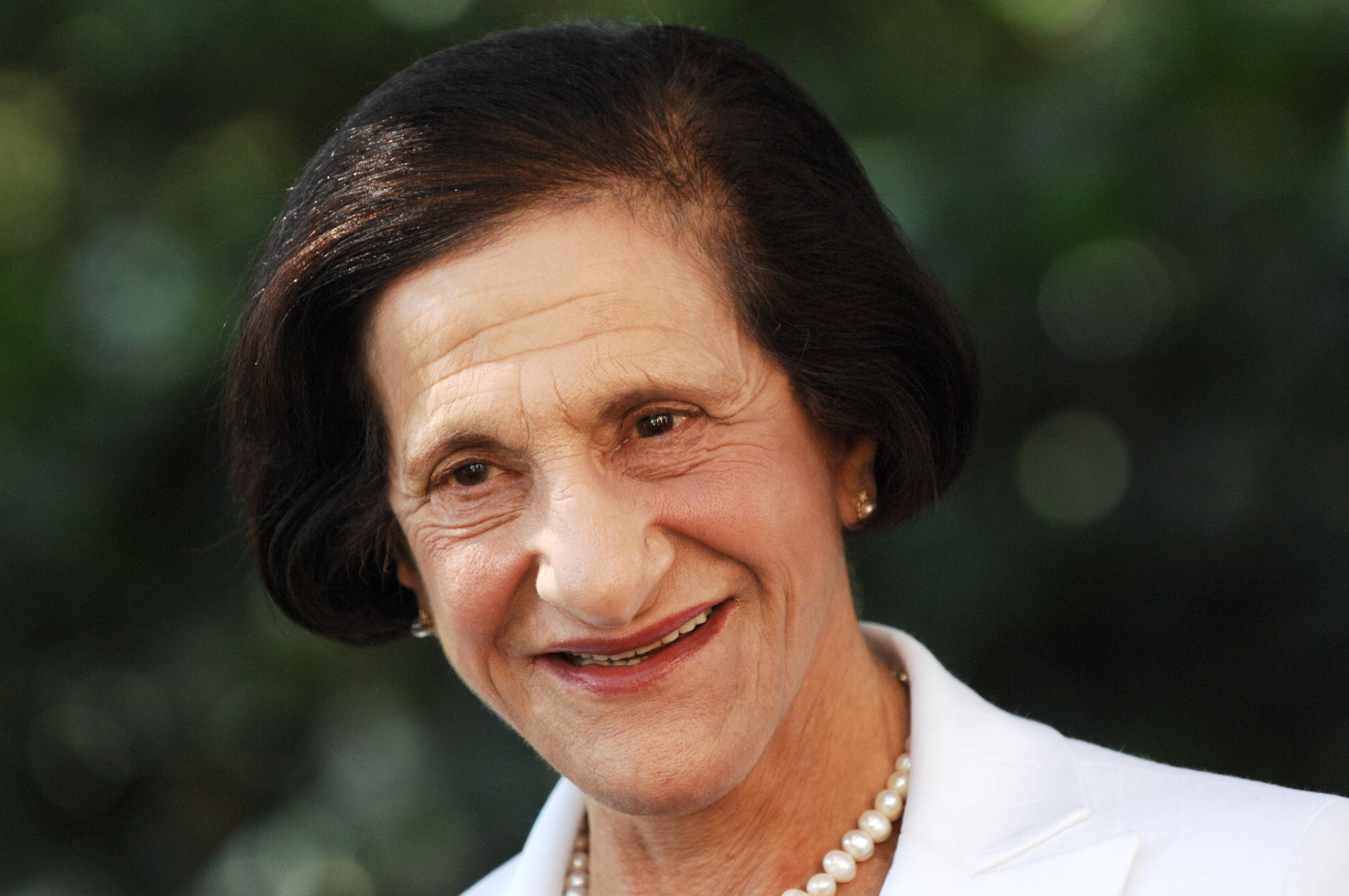 Foto de uma mulher mais velha com cabelo curto tingido de preto.