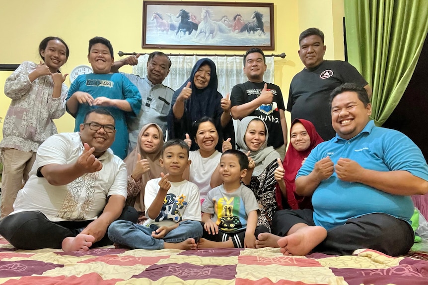 A group of Indonesian people posing for a photo during Eid celebration. 