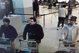 Three suspects pushing trolleys through Brussels airport.
