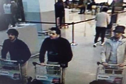 Three suspects pushing trolleys through Brussels airport.