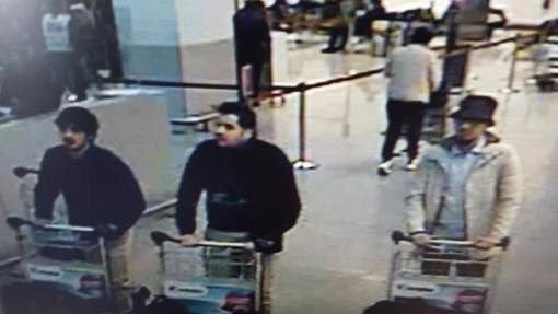 Three suspects pushing trolleys through Brussels airport.