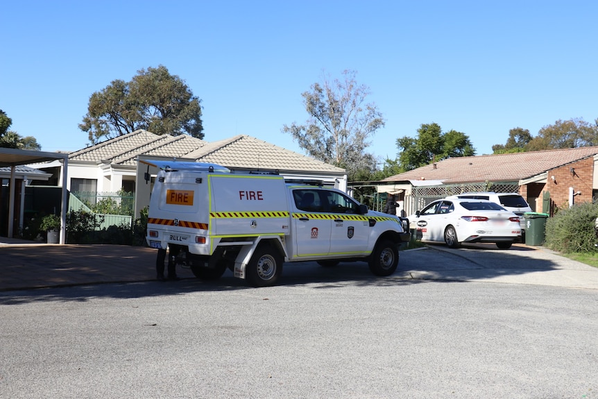A white DFES vehicle parked outside a house, with a taxi next to it.