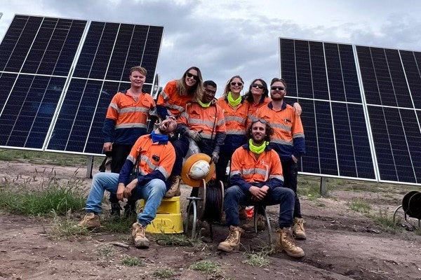 Workers doing silly poses in a group photo on a solar farm in Australia.