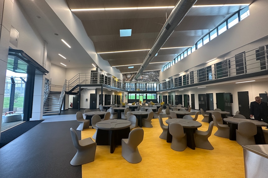 Tables and chairs in a two-level dormitory building.