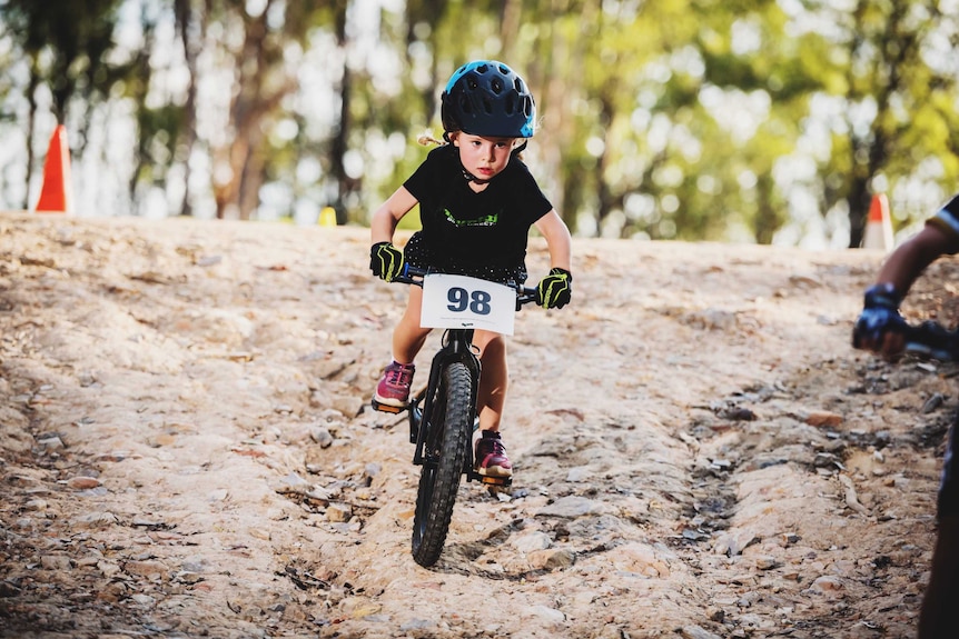 Esther Geale rides a mountain bike depicting healthy ways children can engage with body positivity.