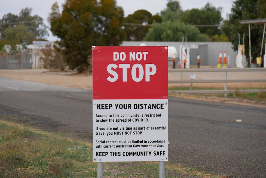 A sign headlined "DO NOT STOP" and explanatory text, set up next to a road.