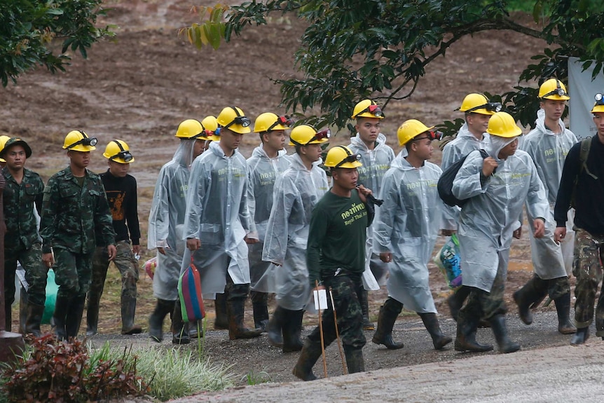 Rescuers walk toward the entrance to a cave complex where five were still trapped.