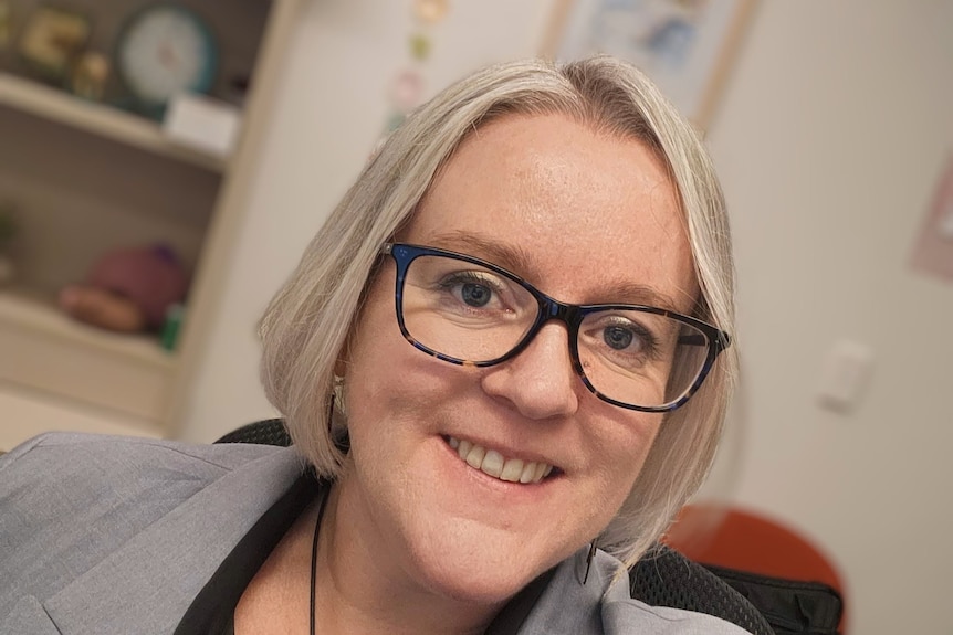 A woman with white hair and dark glasses