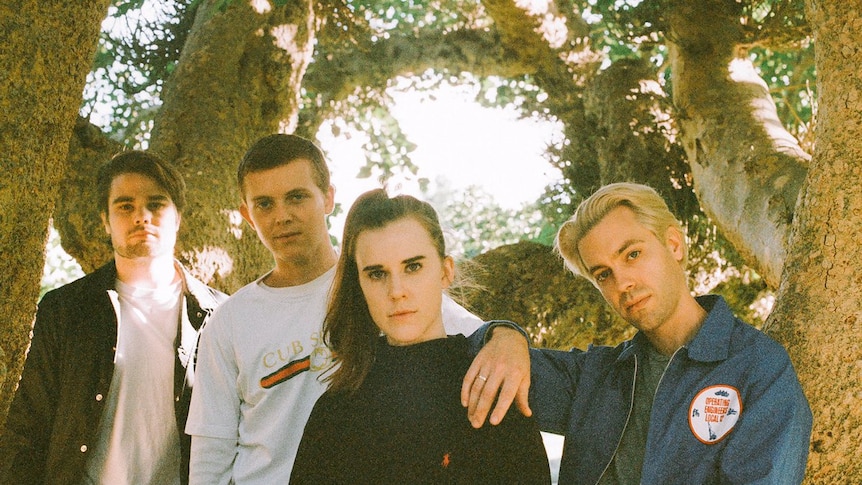 The band Cub Sport. A picture of the band in front of trees, the image has a yellow hue