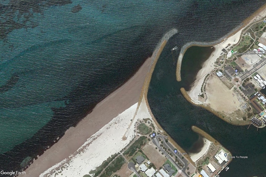 An aerial photo of where an inlet meets the ocean