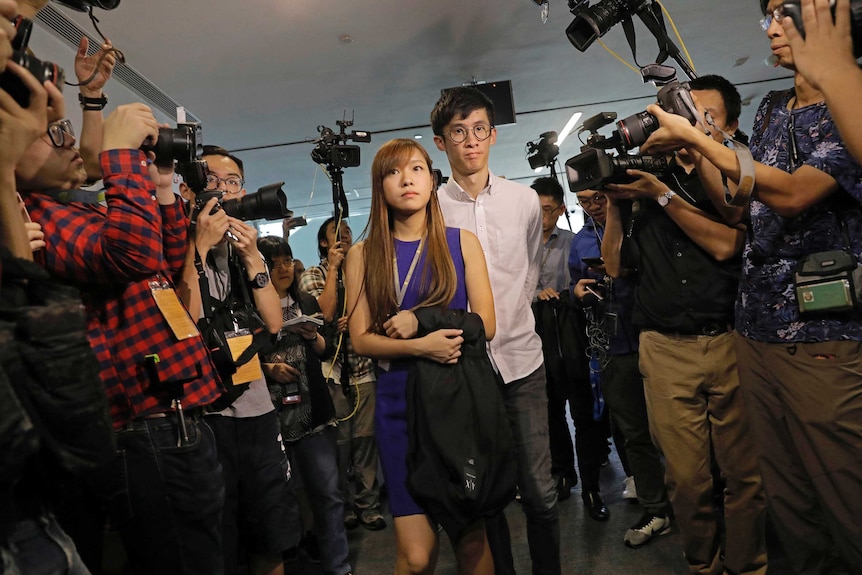 Newly elected Hong Kong lawmakers Yau Wai-ching and Sixtus 'Baggio' Leung surrounded by photographers.