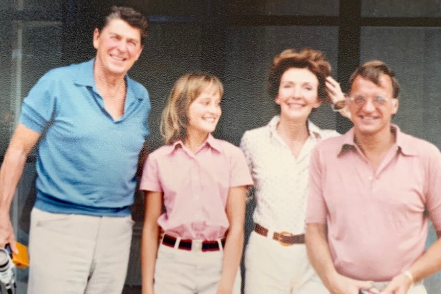 Ronald Reagan, Clare Cannon, Nancy Reagan and Gordon Darling stand in front of a homestead smiling.