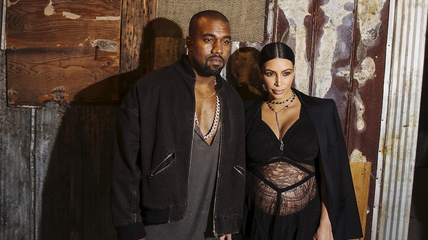 Kanye West and Kim Kardashian pose for photos.