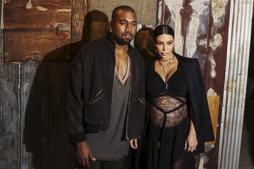 Kanye West and Kim Kardashian pose for photos.