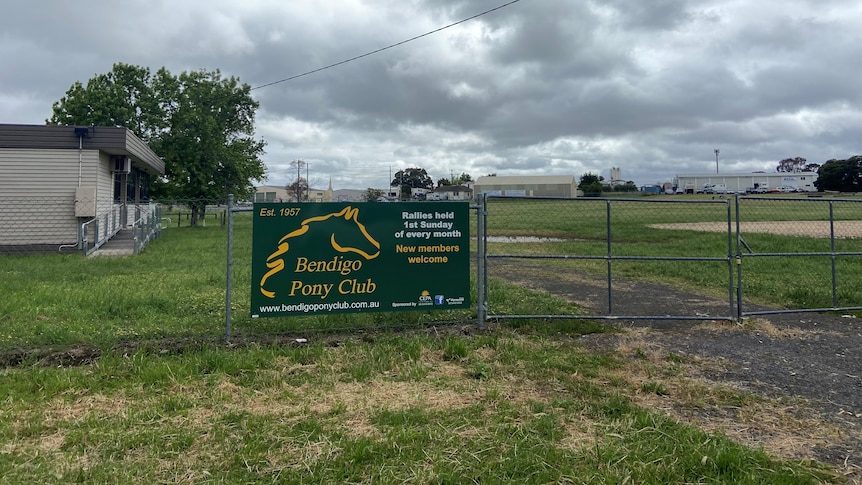 a sign saying 'bendigo pony club' on a security fence around a paddock 