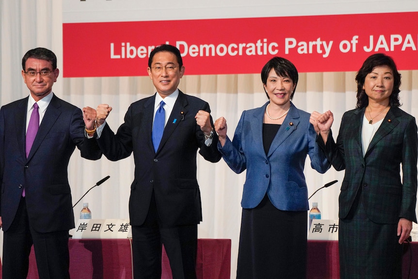 Two men and two women hold up fists to announce candidacy Japanese PM.