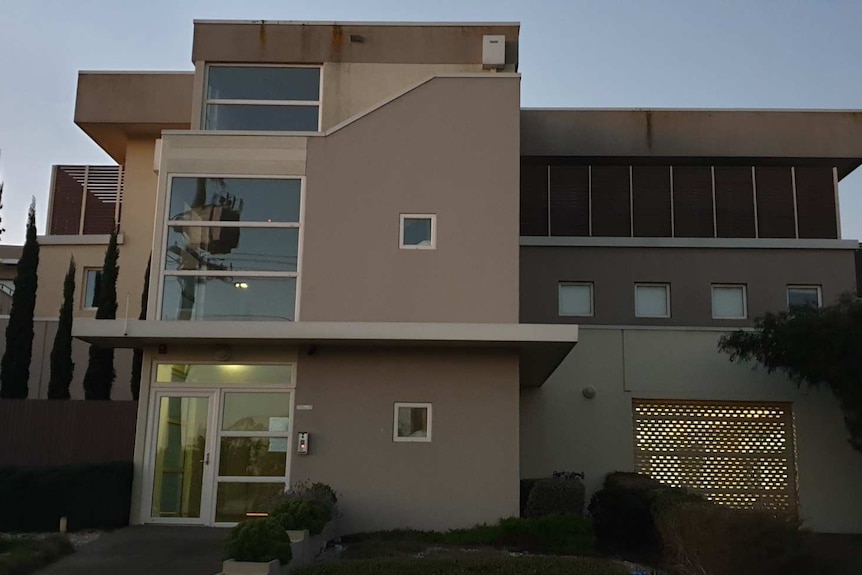 A low rise apartment building at dusk.