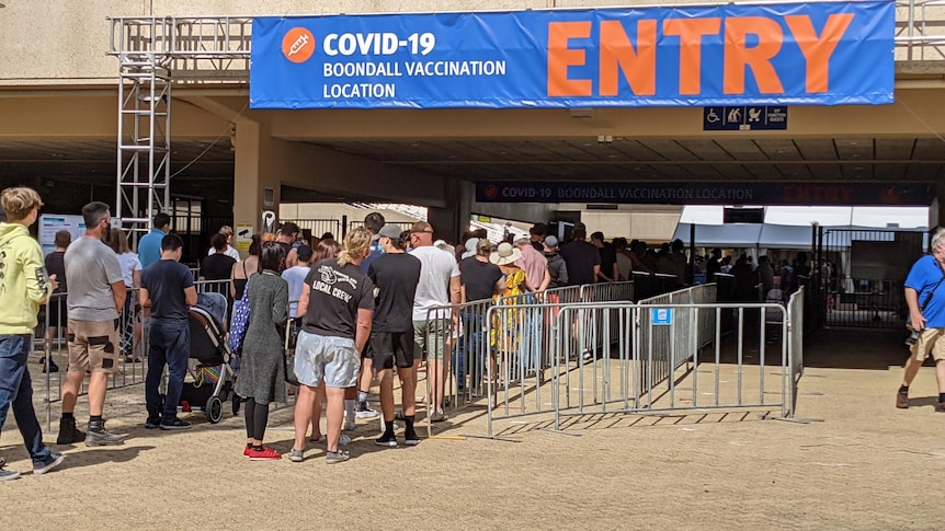A queue of people entering a COVID vaccination hub at Boondall