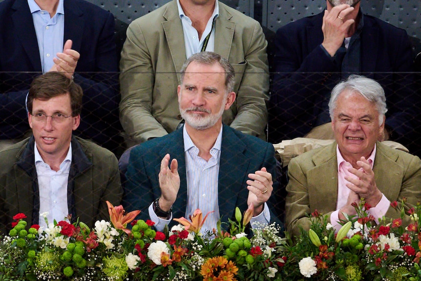 King Felipe VI of Spain sits between other dignitaries in the crowd at Rafael Nadal's match