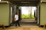 A man stands outside a demountable building on Manus Island