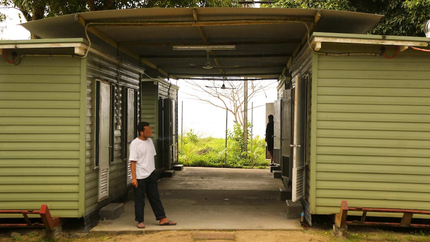 A man stands outside a demountable building on Manus Island