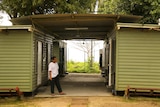 A man stands outside a demountable building on Manus Island.