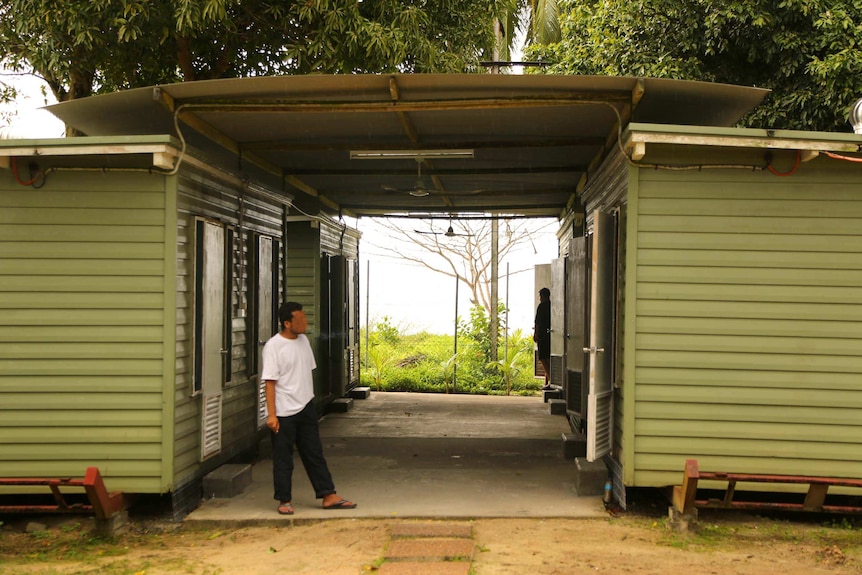 A man stands outside a demountable building on Manus Island