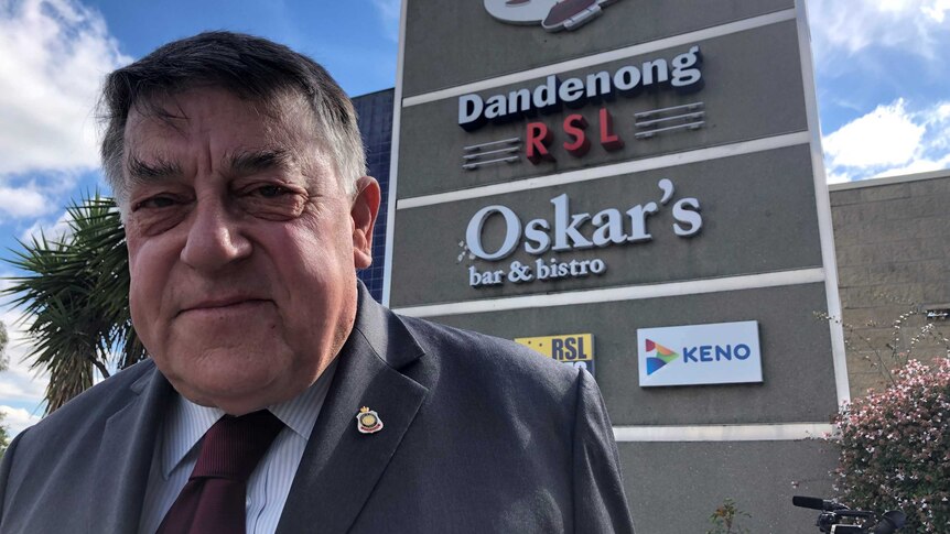 John Wells, President of the Dandenong RSL, standing in front of the RSL sign