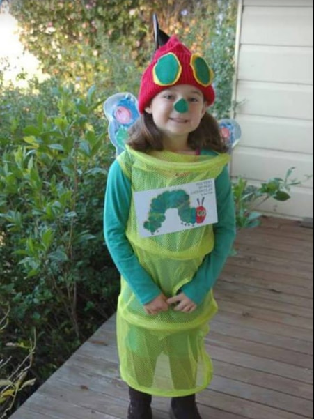 A young girl dressed up as a caterpillar from The Very Hungry Caterpillar