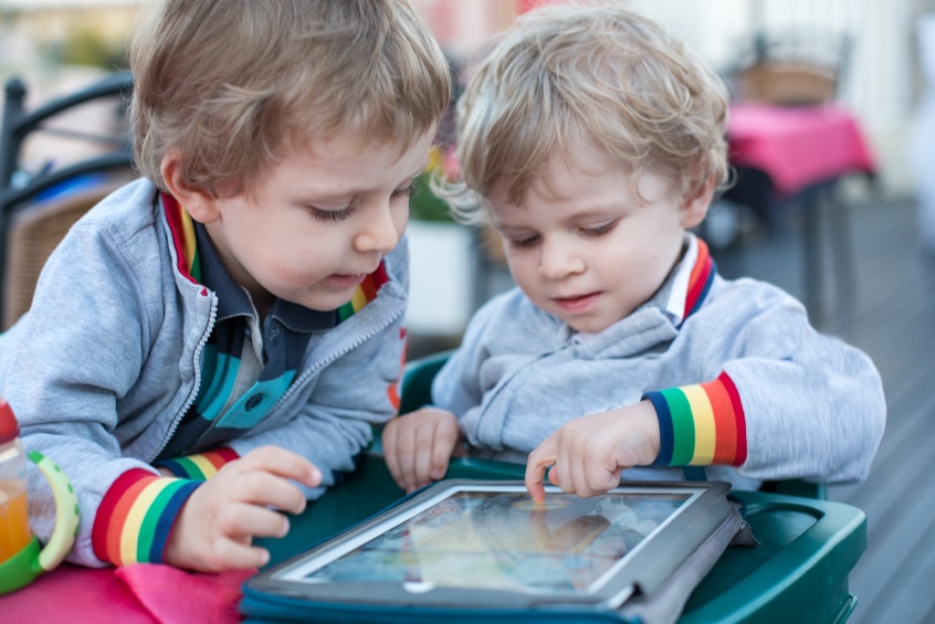 Two little boys using a tablet mobile device