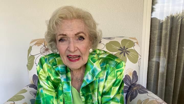 Betty White sits on armchair smiling 