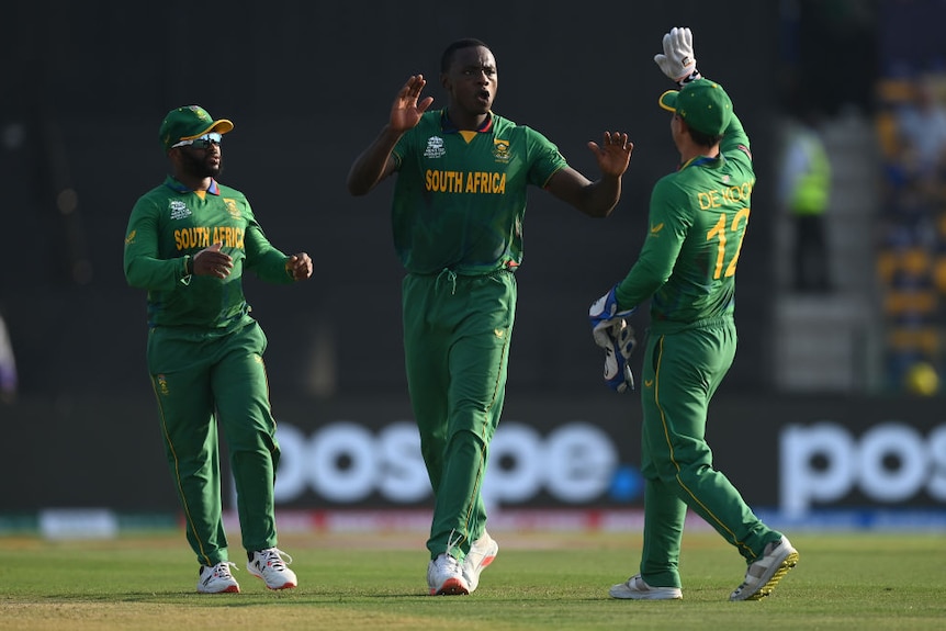 Two men of African descent celebrate a wicket with Quinton De Kock