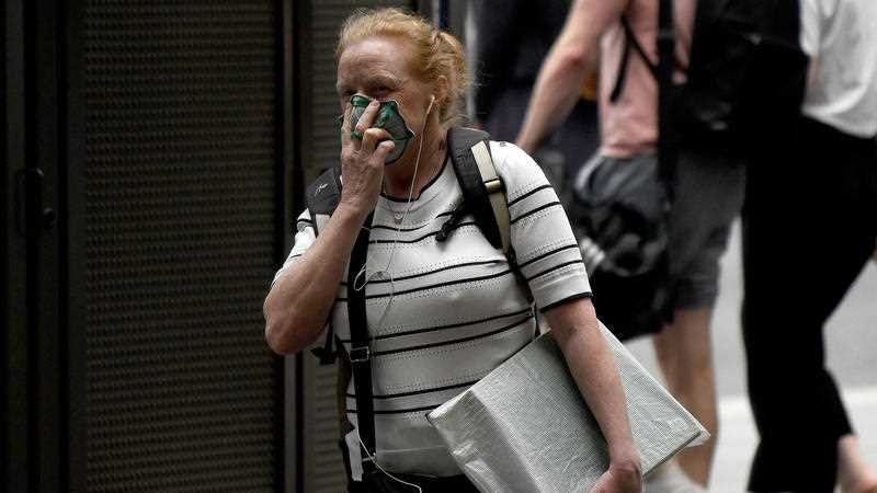 A woman with a face mask on in a Sydney street.