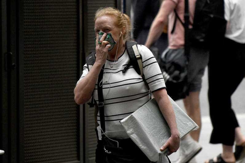 A woman with a face mask on in a Sydney street.