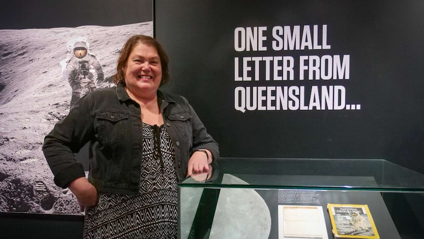 Lady standing near her handwritten letter.