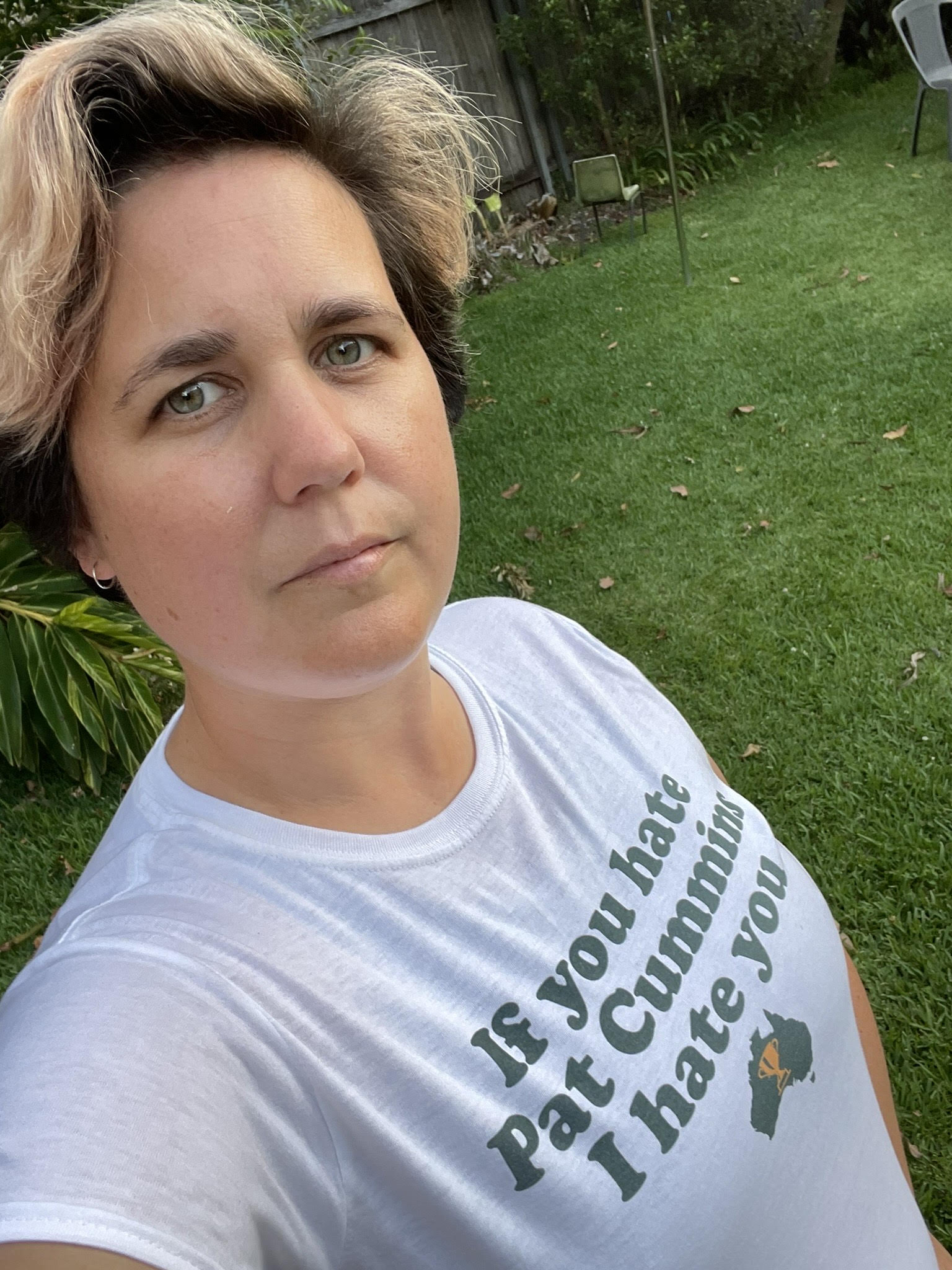 Selfie of Megan Maurice, with short hair, closed mouth smile and tshirt with line: If you hate Pat Cummings, I hate you.