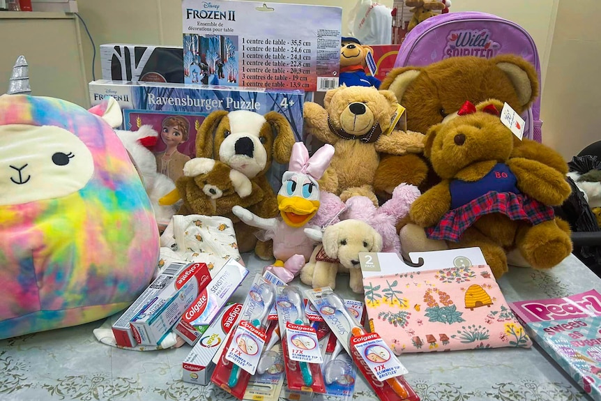 A table full of soft toys, toothbrushes and other gifts.