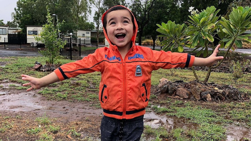 Four year old Freddie Griffin is loving the rain at Cloncurry. 