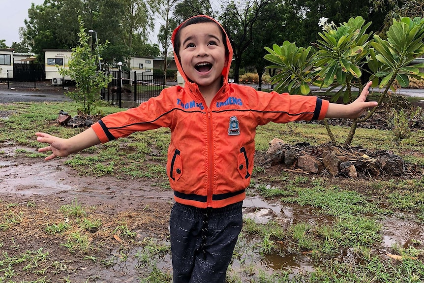 Four year old Freddie Griffin is loving the rain at Cloncurry. 