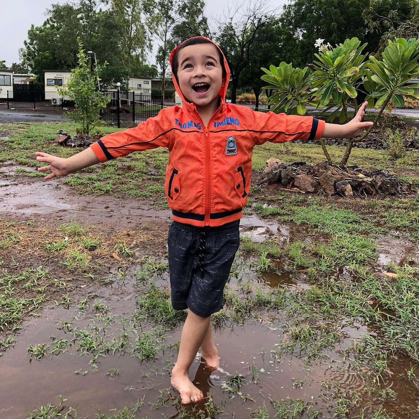 Four year old Freddie Griffin is loving the rain at Cloncurry. 