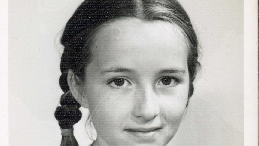 black and white image of girl with hair in plaits wearing large gingham print top
