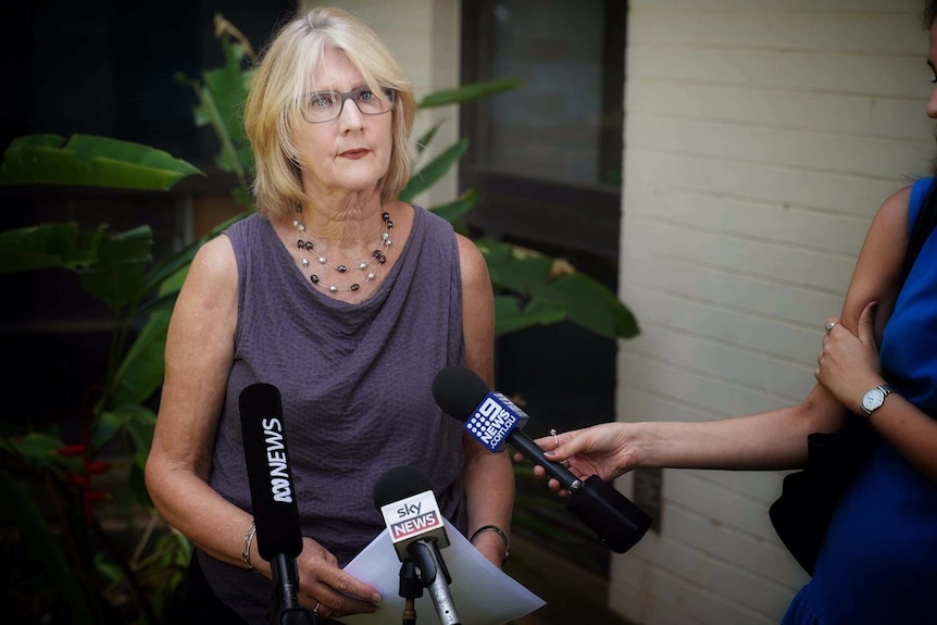 Woman speaking to journalists at press conference.