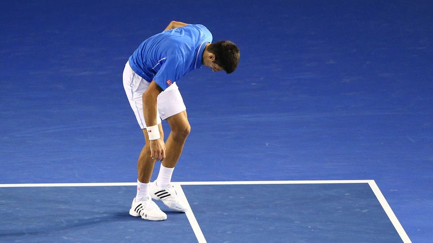 Novak Djokovic of Serbia drops his racquet in his men's final match
