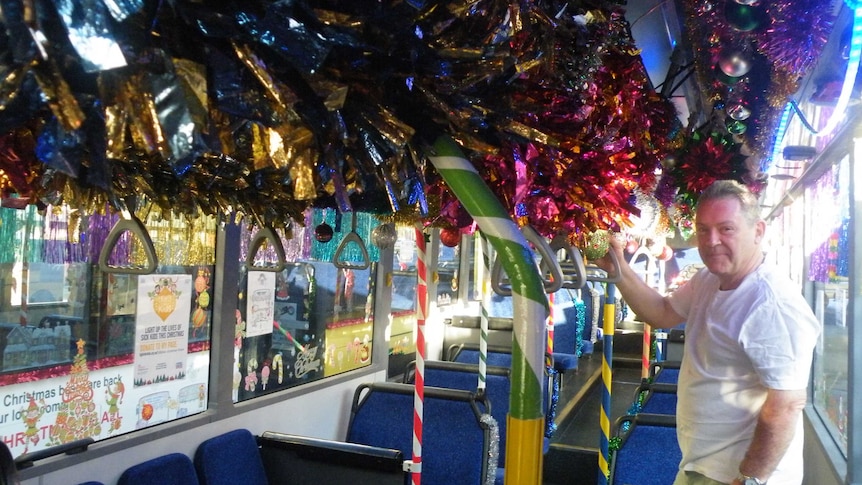 Peter Edward Rose standing on a very decorated Christmas themed bus