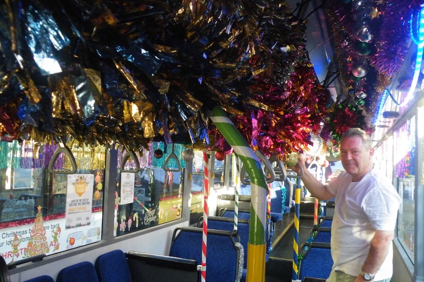 Peter Edward Rose standing on a very decorated Christmas themed bus