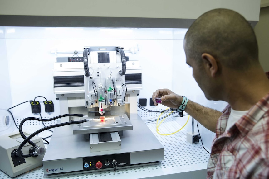 Professor Tal Dvir inspects the process of 3D printing a heart
